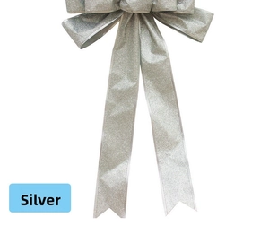 Close-up of glittery silver Christmas bow ornament with shimmering texture and ribbons