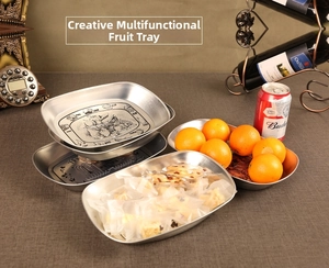 Detailed view of vintage European tin trays with elegant fruit basket patterns and relief edges