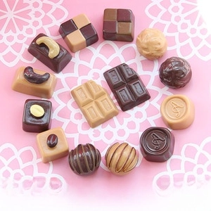 Macro shot of assorted resin miniature chocolates with realistic textures and heart shapes