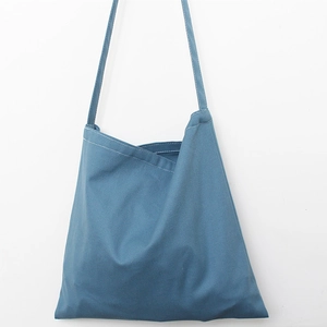 Detail view of the layered opening and blue canvas texture on this minimalist tote bag
