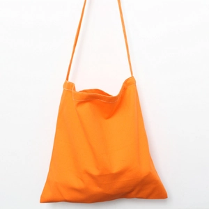 Detail of bright orange canvas tote bag showing white double-needle stitching on top
