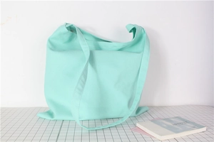 Detailed close-up of mint green canvas tote bag fabric and wide shoulder strap