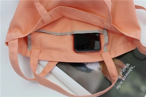 Close-up of peach canvas bag interior with a phone pocket and detailed stitching