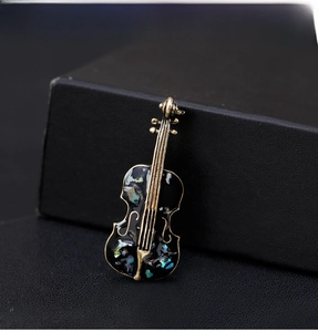 Close-up of vintage cello brooch with iridescent shell inlay on jewelry box