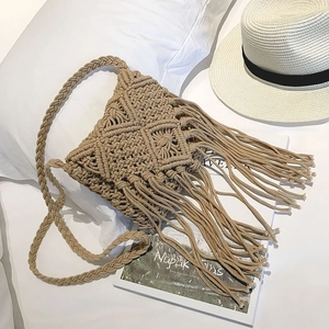 Gros plan sur la texture tissée en coton kaki et les franges bohèmes sur le sac à bandoulière