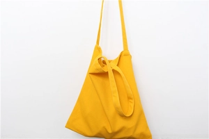 Close-up of bright yellow canvas tote bag showing high-density fabric texture and strap