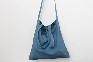 Detailed view of navy blue canvas tote bag showing white contrast stitching and straps