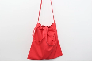 Detail view of red canvas tote bag showing stitching and durable fabric texture
