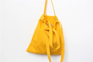 Detailed view of durable bright yellow canvas tote bag with white contrast stitching