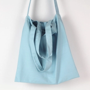 Detailed texture of light blue canvas tote bag showing durable fabric and double handles