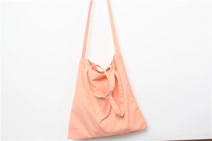 Detail view of pink canvas tote bag with dual straps and spacious interior design