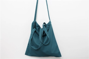 Deep blue canvas tote bag showing stitching details and adjustable shoulder strap