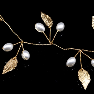 Macro detail of golden leaf hairband with white pearls and handcrafted vine wire