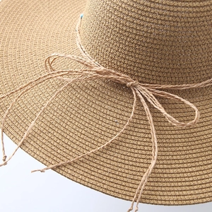 Straw sun hat with wide brim and rope knot detail for summer beach protection