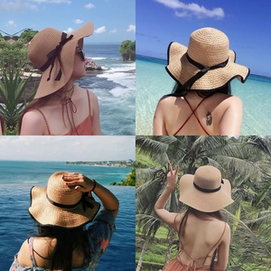 Women's wide brim straw sun hat with black ribbon bow for beach and summer vacations