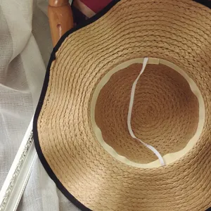 Straw sun hat with wide brim, black edge trim, and interior windproof strap