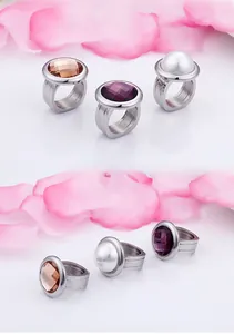 Detail view of bold stainless steel rings set with smoky quartz, purple gem, and white pearl