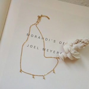 Detail of 925 sterling silver gold beaded necklace with adjustable clasp and logo tag