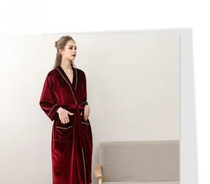 Detail of dark red velvet bathrobe with white contrast piping and elegant waist tie