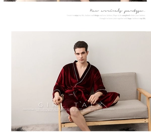 Detail of burgundy velvet robe with white piping and waist tie on a seated male model