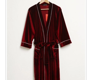 Detail of burgundy velvet robe featuring contrast white trim and soft textile texture