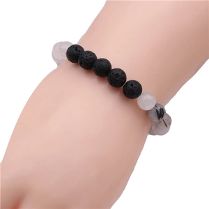 Détail des perles de pierre volcanique noire de 8mm et cristal sur le bracelet