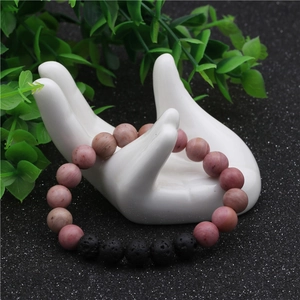 Vue détaillée du bracelet en cristal rose et pierre de lave sur support en céramique