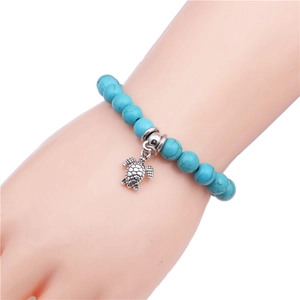 Bracelet en perles de turquoise avec pendentif tortue en argent antique au poignet