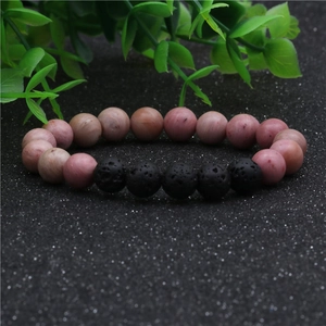 Vue macro de perles en pierre naturelle rose 8mm et pierre de lave noire sur le bracelet