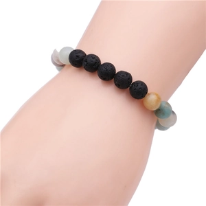 Vue détaillée d'un bracelet en pierre de soleil de 8 mm et perles de lave noire au poignet