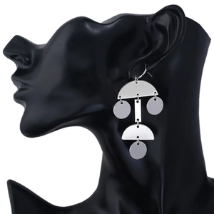 Silver geometric earrings on a black mannequin featuring rectangular and circular charms