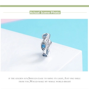 Macro detail of S925 sterling silver evil eye charm with blue gemstones on a white base