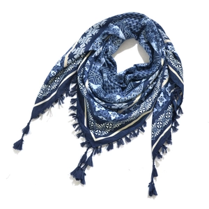 Detail view of blue bohemian triangle scarf featuring paisley patterns and knotted tassels
