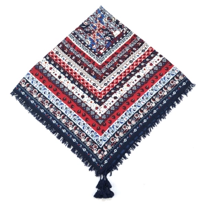 Close-up of bohemian red and blue paisley pattern square scarf with decorative tassels