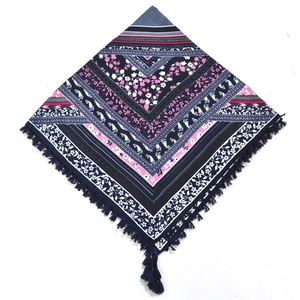 Detail of bohemian scarf showing intricate floral paisley patterns and navy blue tassels