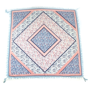 Close-up of Bohemian floral pattern and knotted fringe details on square scarf