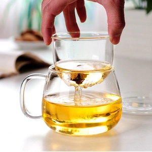 Heat resistant borosilicate glass tea cup with infuser showing tea filtering process