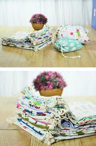 Detail view of assorted printed cotton linen drawstring storage bags on a wooden table