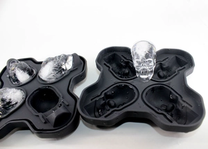 Detail of black silicone skull ice molds showing textured trays and realistic ice shapes