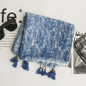 Detail of blue feather print cotton linen scarf with elegant tassel trim and decorations