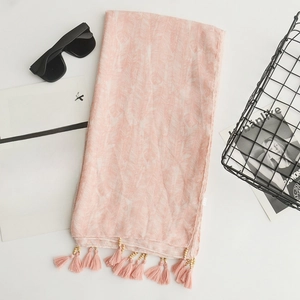 Pink cotton linen scarf with tassels displayed with sunglasses and a decorative basket