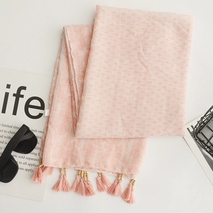Pink bohemian linen scarf with delicate wooden beads and tassels on white background