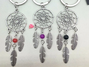 Detailed view of three metal dreamcatcher keychains with red, purple, and black beads