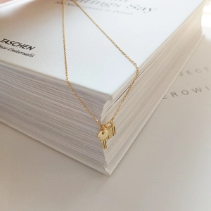 Macro detail of 925 sterling silver gold-plated lock and key pendant on book edge