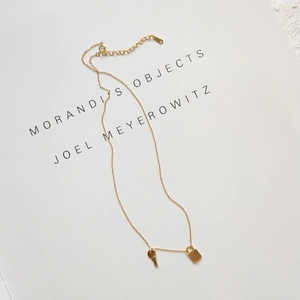 Close-up of a 925 silver gold-plated necklace featuring unique lock and key pendants