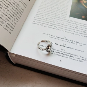 Close-up of vintage 925 silver ring with oval relief on an art book background