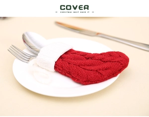Détail d'un porte-couverts en forme de chaussette de Noël tricotée rouge et blanc