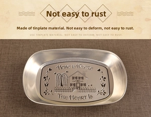 Macro detail of silver tinplate tray with engraved vintage house and heart motif
