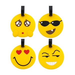 Detail of four yellow silicone luggage tags featuring various cartoon emoji facial expressions
