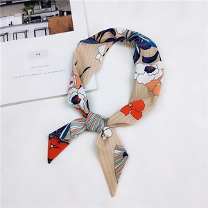Dettaglio di foulard in seta con fiori arancio e strisce blu in layout di stile